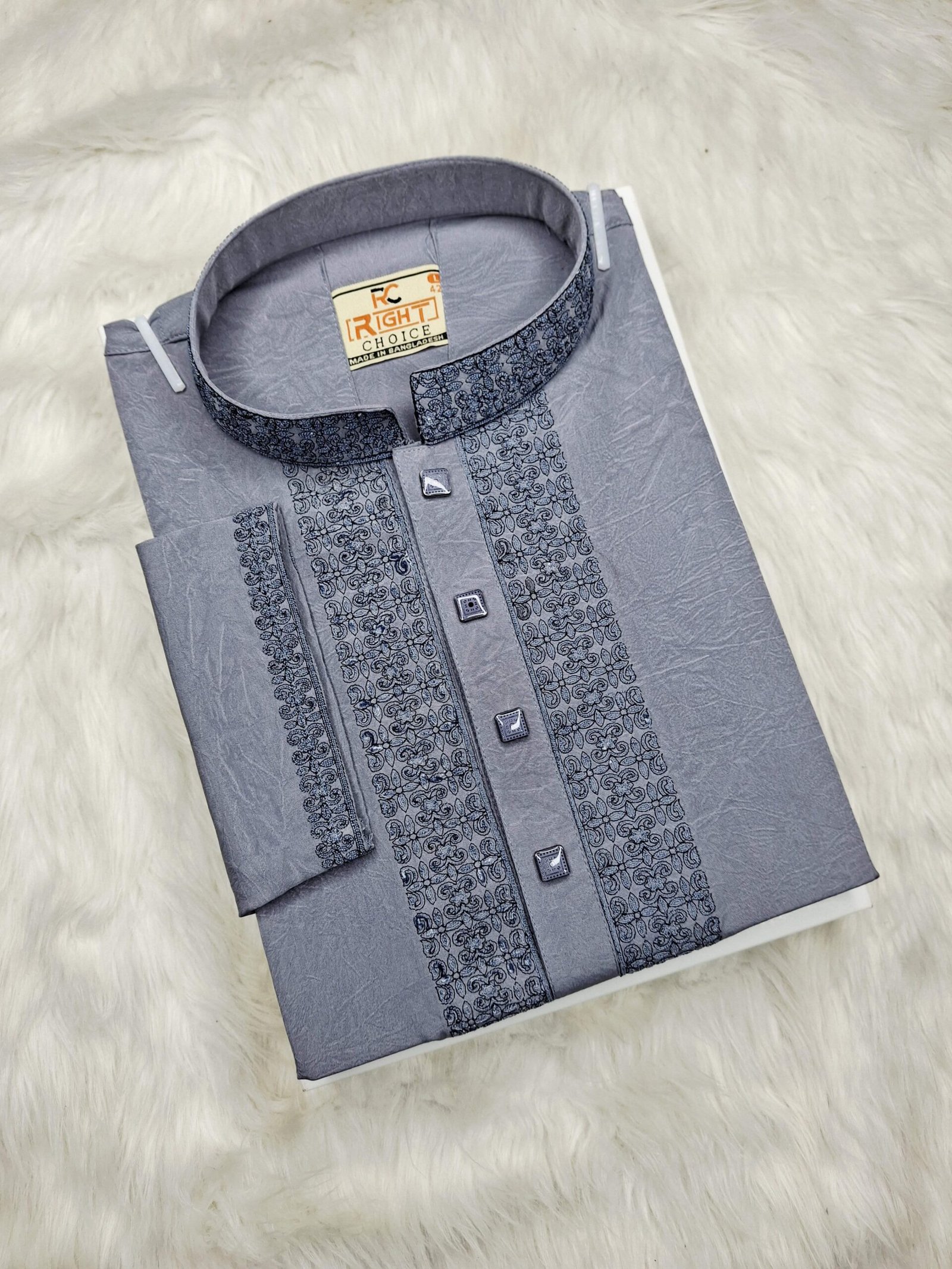 Ash Panjabi with detailed flat embroidery on the front and collar, neatly folded on a soft fur background.